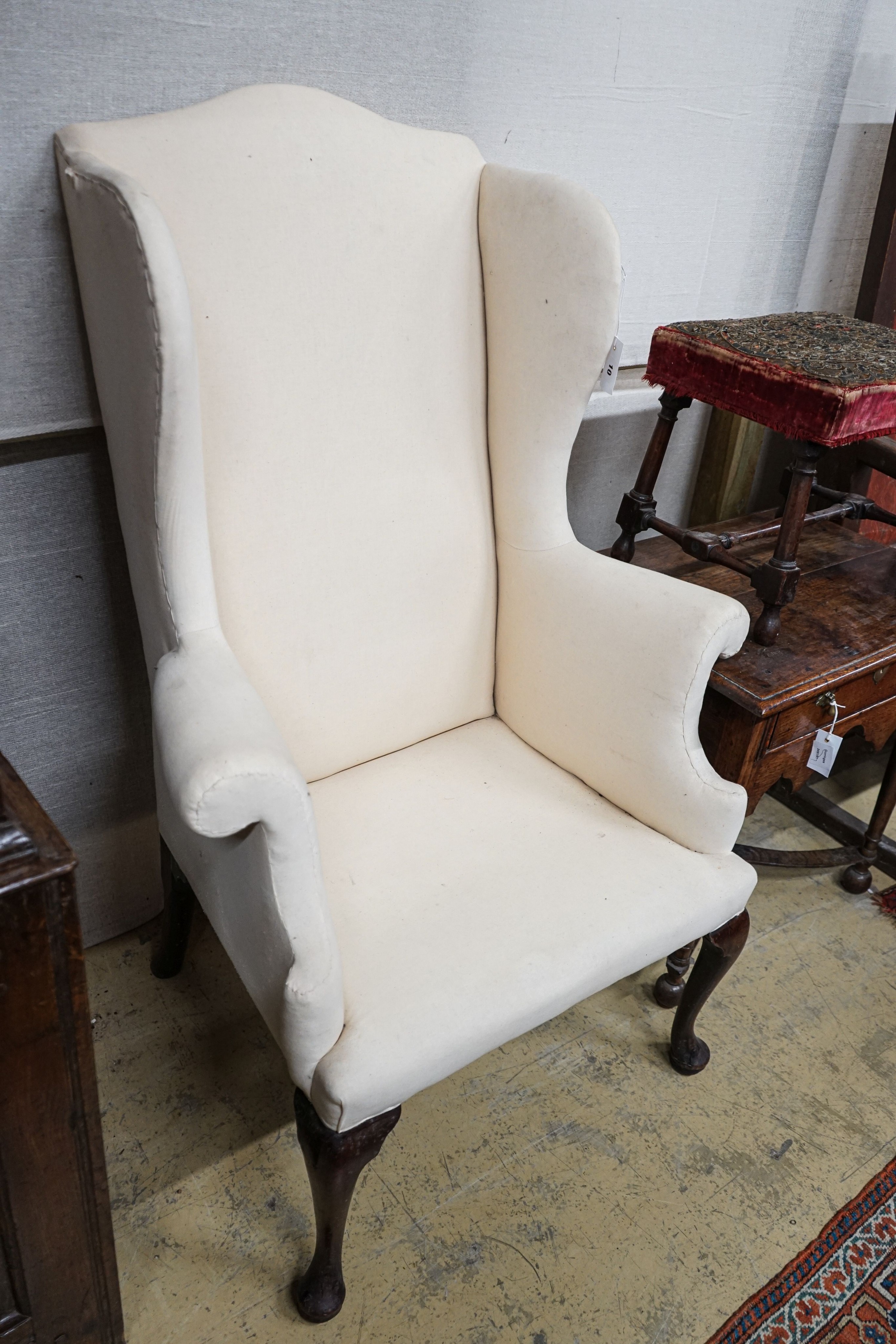 A George II mahogany wingback armchair, with slender cabriole legs and pad feet, width 80cm, depth 66cm, height 126cm